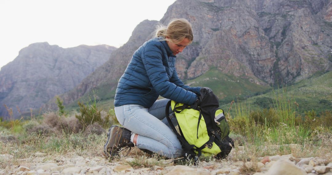 Woman Kneeling in Outdoor Gear Packing Backpack in Mountainous Area - Free Images, Stock Photos and Pictures on Pikwizard.com