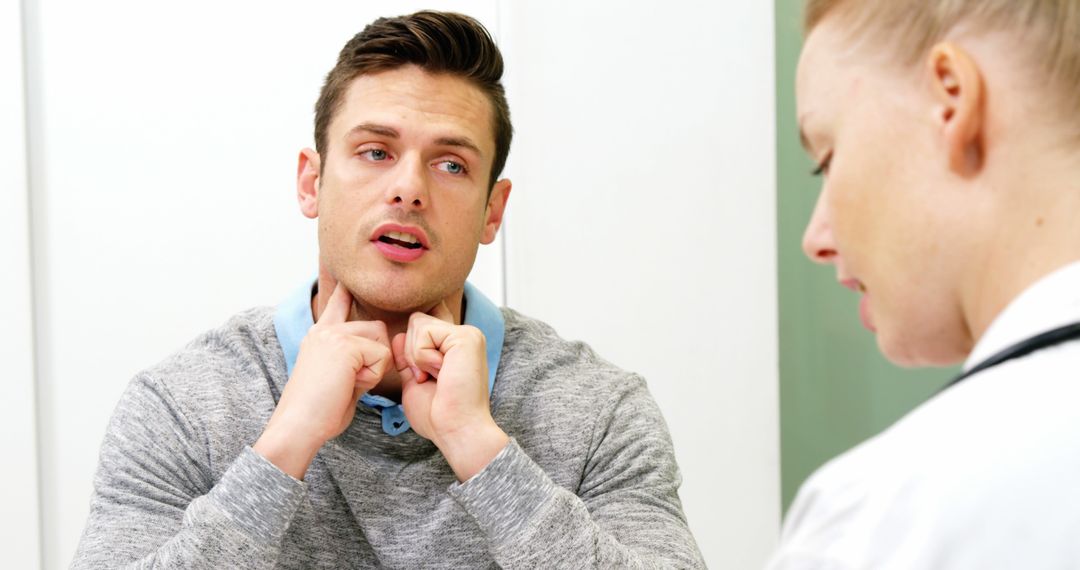 Man Describing Throat Pain to Female Doctor in Medical Consultation - Free Images, Stock Photos and Pictures on Pikwizard.com