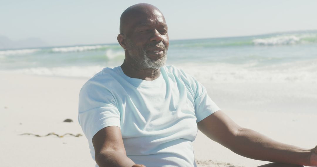 Senior african american couple practicing yoga and meditating on sunny beach - Free Images, Stock Photos and Pictures on Pikwizard.com