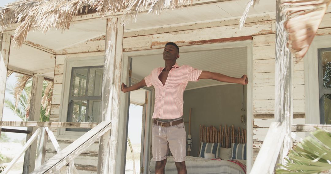 Man Stretching on Porch of Rustic Beach House - Free Images, Stock Photos and Pictures on Pikwizard.com