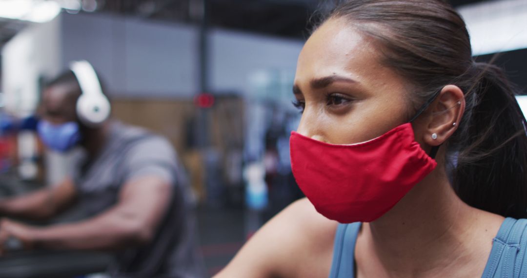 Focused Woman Working Out at Gym Wearing Red Face Mask - Free Images, Stock Photos and Pictures on Pikwizard.com