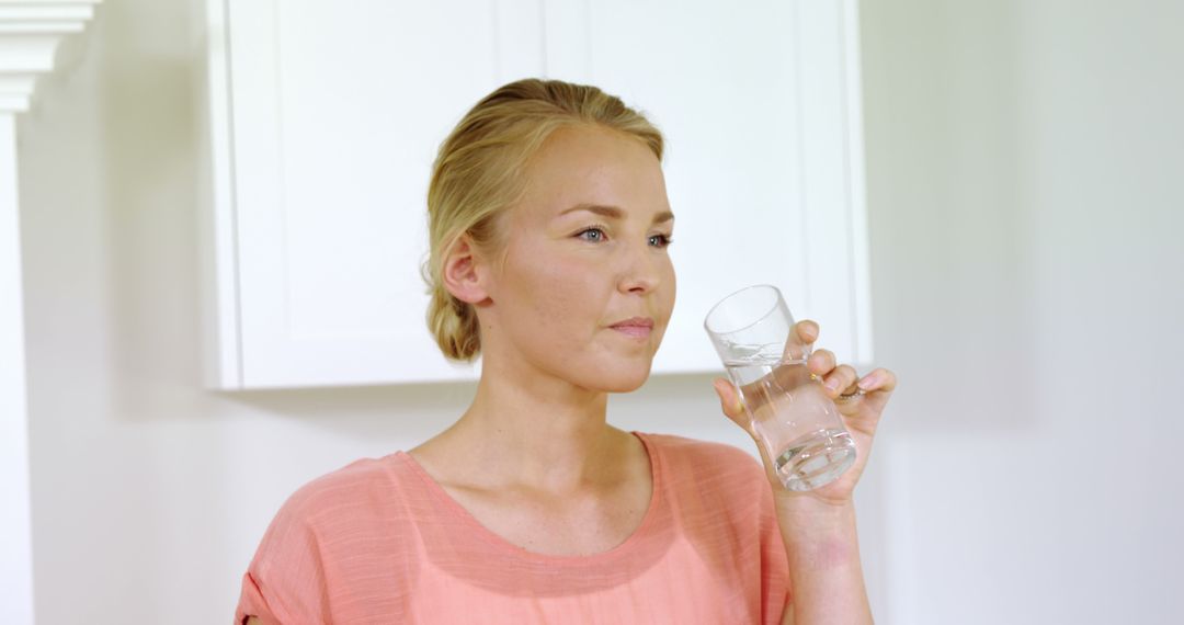 Woman Drinking Water in Bright Kitchen - Free Images, Stock Photos and Pictures on Pikwizard.com