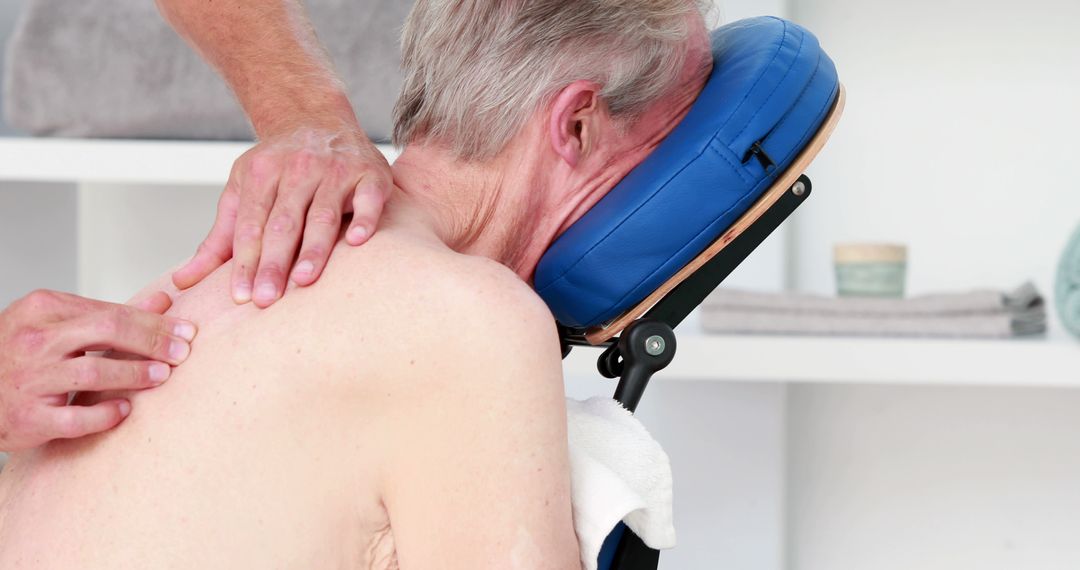 An elderly man gets a therapeutic neck massage with a device for pain relief and relaxation. - Free Images, Stock Photos and Pictures on Pikwizard.com