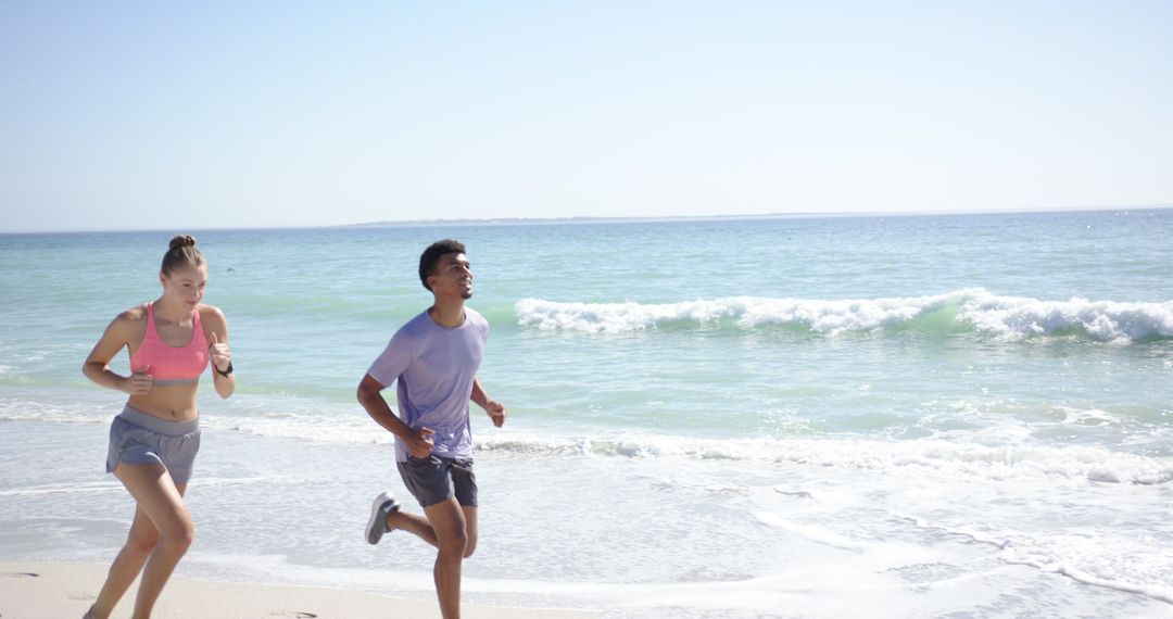 Young Individuals Enjoying Jogging on Sunny Beach