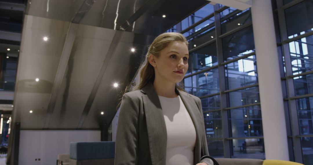 Businesswoman in Modern Office Building with Large Windows - Free Images, Stock Photos and Pictures on Pikwizard.com