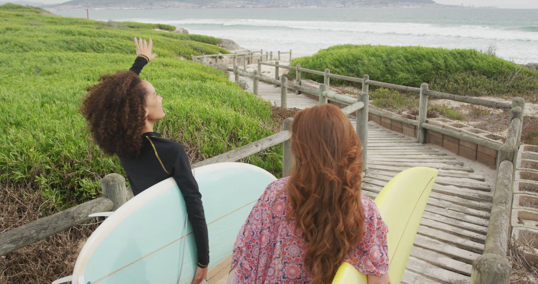 Two Women Carrying Surfboards and Heading Towards the Ocean - Free Images, Stock Photos and Pictures on Pikwizard.com