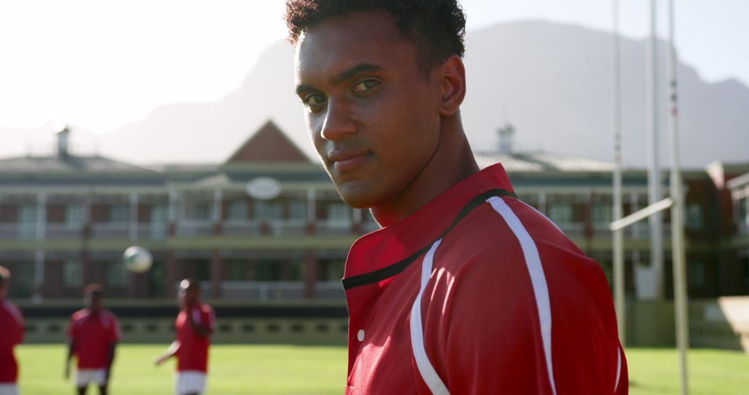 Focused Rugby Player in Red Uniform on Sunny Field