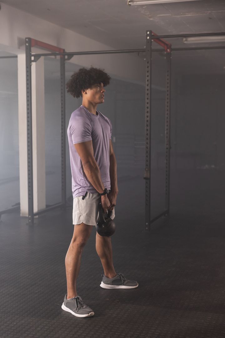 Man Concentrating on Kettlebell Exercise in Modern Gym