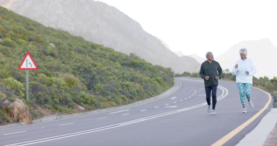 Senior Couple Enjoying Morning Jog on Mountain Road - Free Images, Stock Photos and Pictures on Pikwizard.com