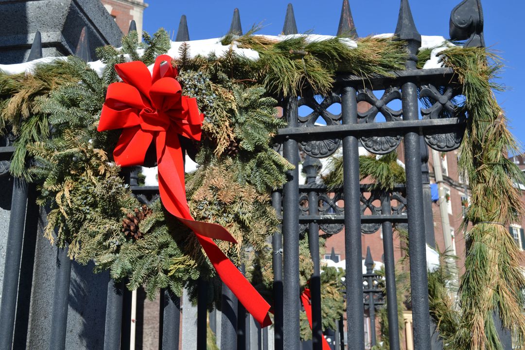 Festive Wreath with Red Bow on Iron Gate Outdoors - Free Images, Stock Photos and Pictures on Pikwizard.com