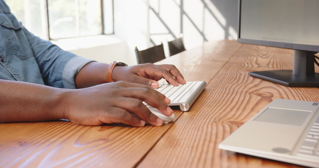 Hands Typing on Wireless Keyboard in Modern Office Setting