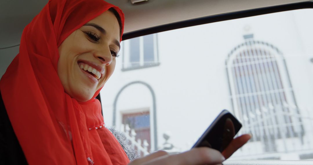 Smiling Woman in Hijab Enjoys Smartphone in Car - Free Images, Stock Photos and Pictures on Pikwizard.com