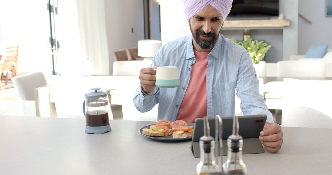 Man in Turban Enjoying Breakfast and Using Tablet at Home