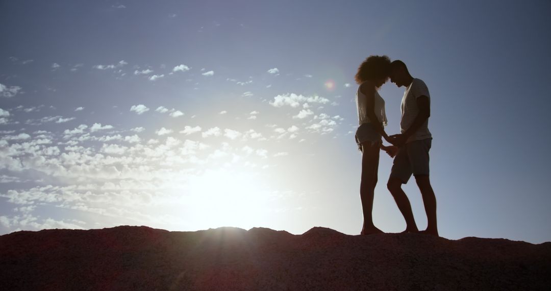 Silhouette of Romantic Couple Embracing at Beach Sunset