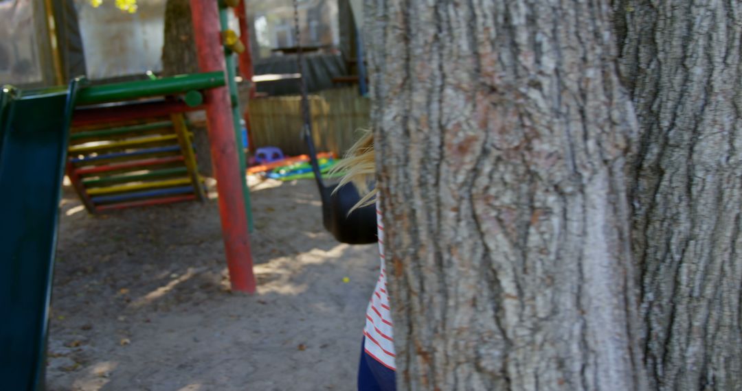 Child Playing Hide and Seek Behind Tree in Playground - Free Images, Stock Photos and Pictures on Pikwizard.com