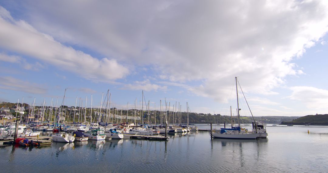 Scenic Marina with Sailboats Docked on Calm Water Under Blue Sky - Free Images, Stock Photos and Pictures on Pikwizard.com