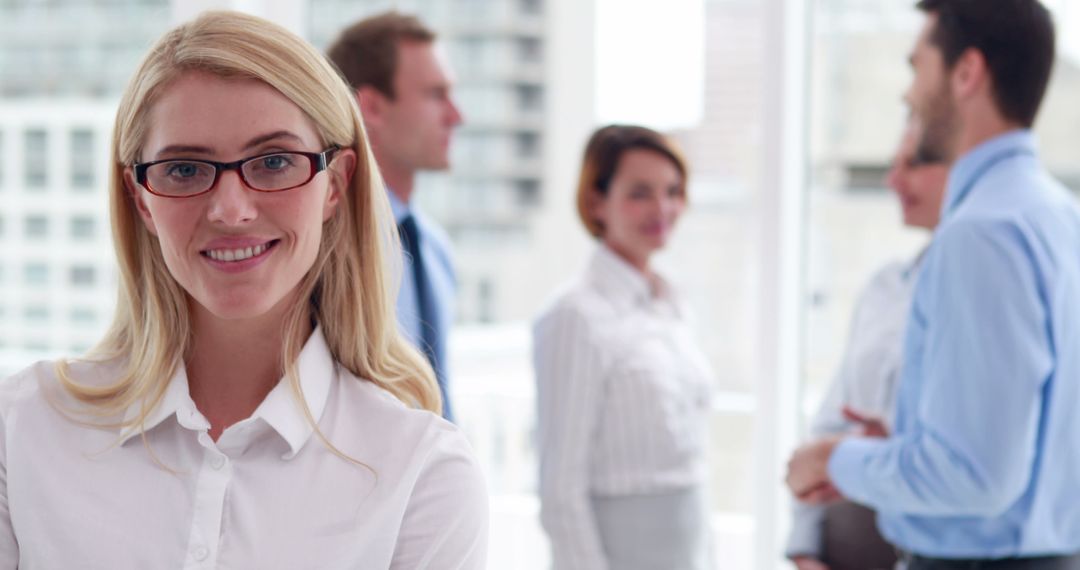 Confident Businesswoman Smiling with Colleagues in Office Background - Free Images, Stock Photos and Pictures on Pikwizard.com