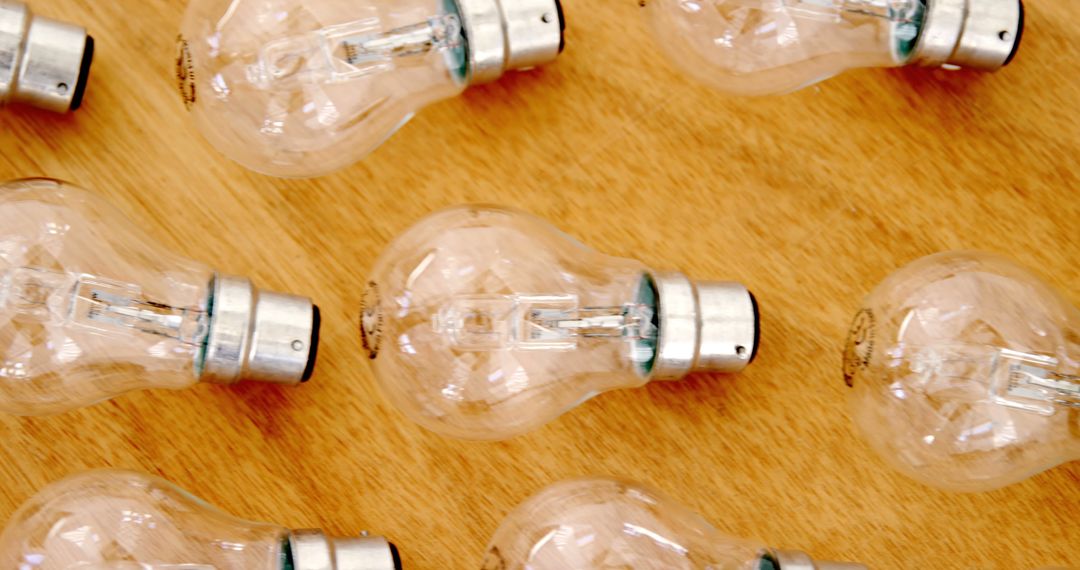 Multiple Clear Light Bulbs Arranged Horizontally on Wooden Surface - Free Images, Stock Photos and Pictures on Pikwizard.com