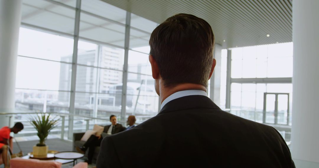 Rear View Asian Businessman in Office Lounge with Team Discussion