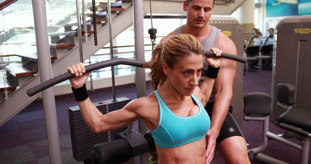 Personal Trainer Assisting Woman with Lat Pulldown Exercise in Modern Gym - Free Images, Stock Photos and Pictures on Pikwizard.com