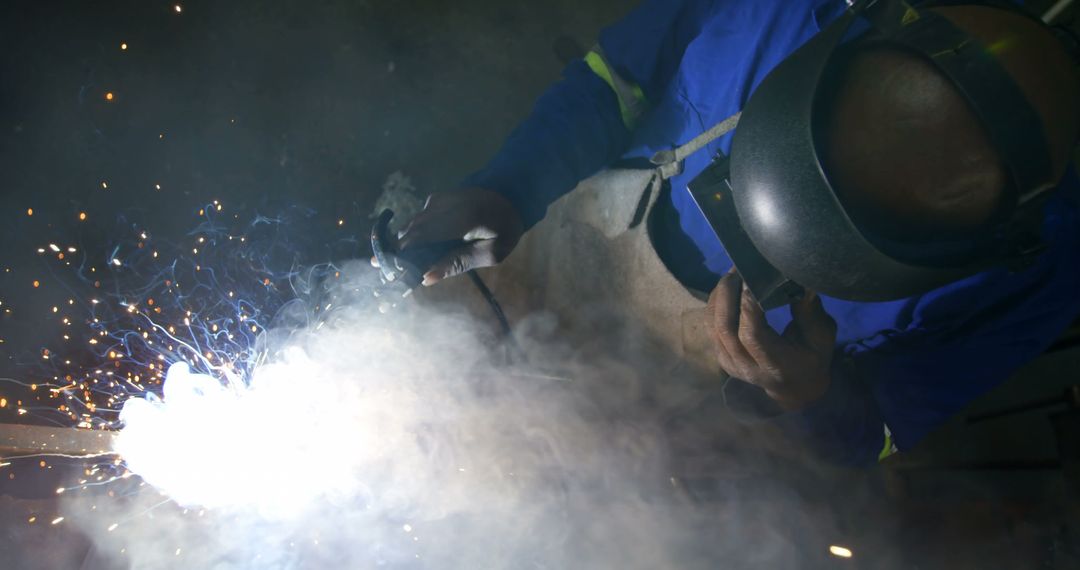 Welder Working with High-Powered Welding Torch Evoking Sparks and Smoke - Free Images, Stock Photos and Pictures on Pikwizard.com