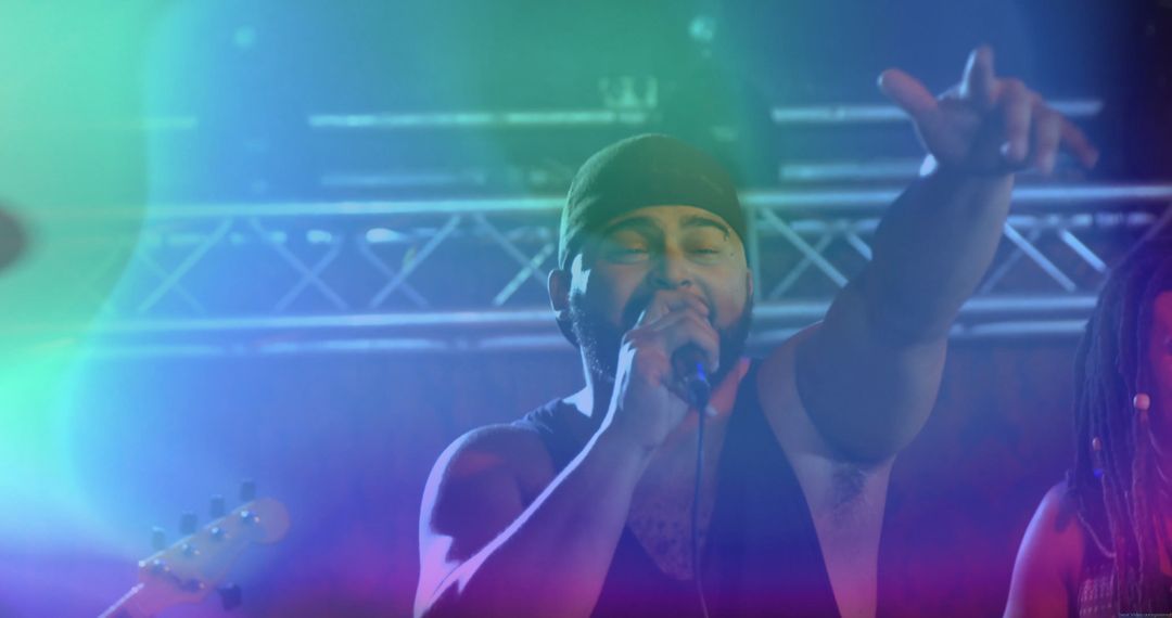 Energized Frontman Engaging Audience on Stage in Colorful Concert