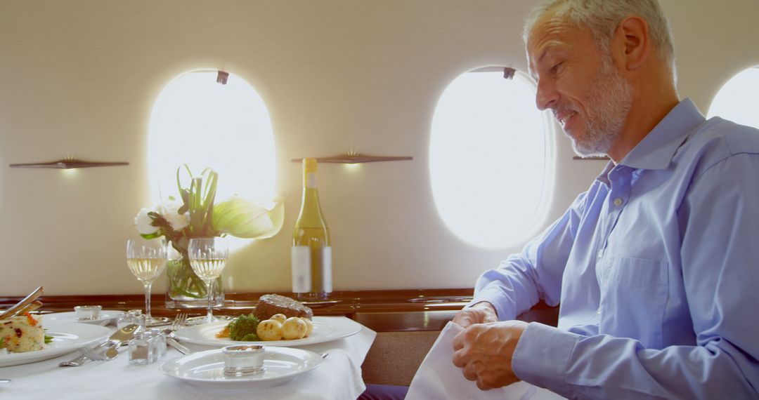 Elderly Man Enjoying Fine Dining Meal in Luxury Private Jet Cabin - Free Images, Stock Photos and Pictures on Pikwizard.com