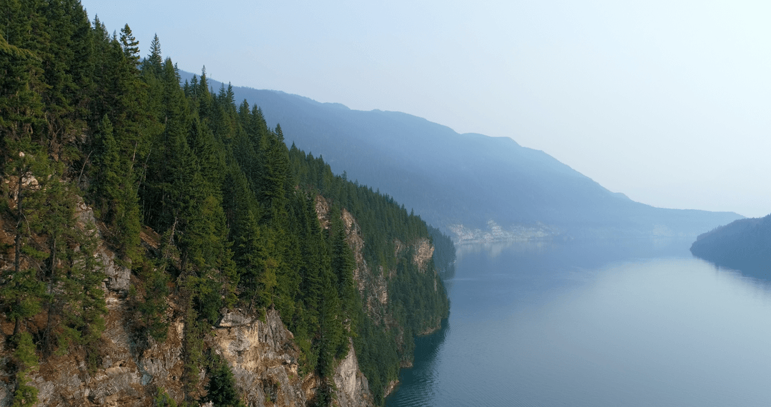 Serene View of Lush Forested Cliffs Along Peaceful River