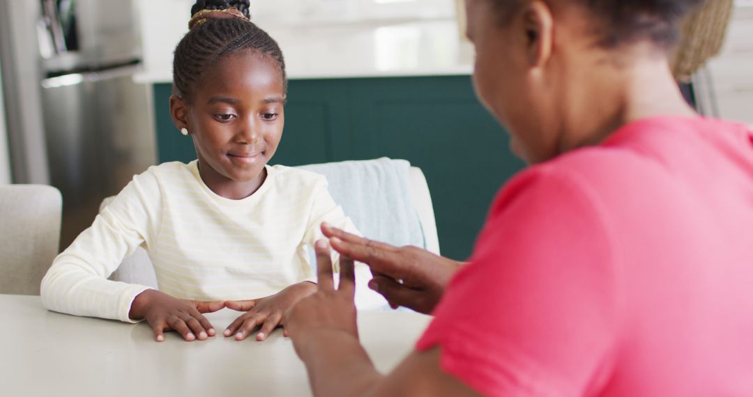 Image of smiling african american granddaughter practicing sign language with her grandmother - Free Images, Stock Photos and Pictures on Pikwizard.com