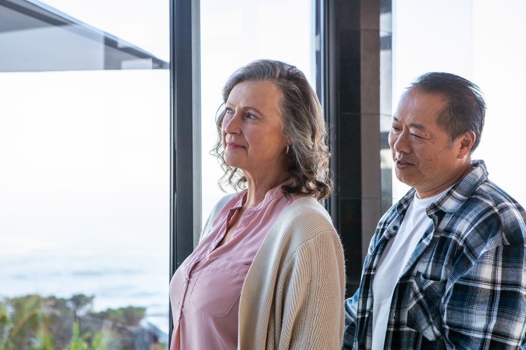 Senior Couple Enjoying Ocean View at Home with Scenic Beachfront