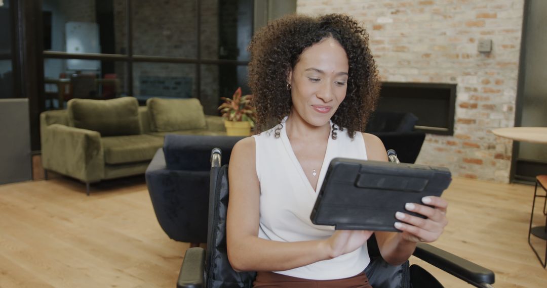 Professional Woman in Wheelchair Using Digital Tablet in Office - Free Images, Stock Photos and Pictures on Pikwizard.com