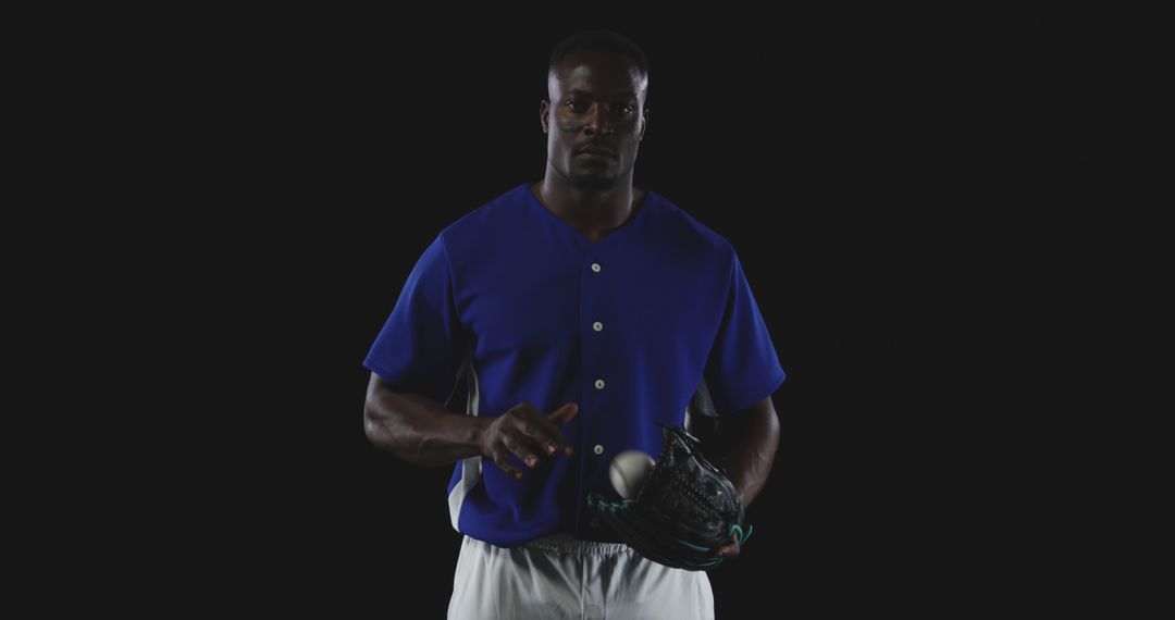 Athletic Man Holding Baseball Glove Isolated on Dark Background - Free Images, Stock Photos and Pictures on Pikwizard.com