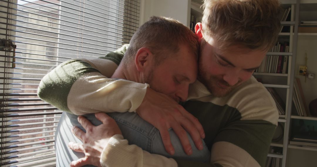 Male Friends Comforting Each Other Through Hug in Sunlit Room - Free Images, Stock Photos and Pictures on Pikwizard.com