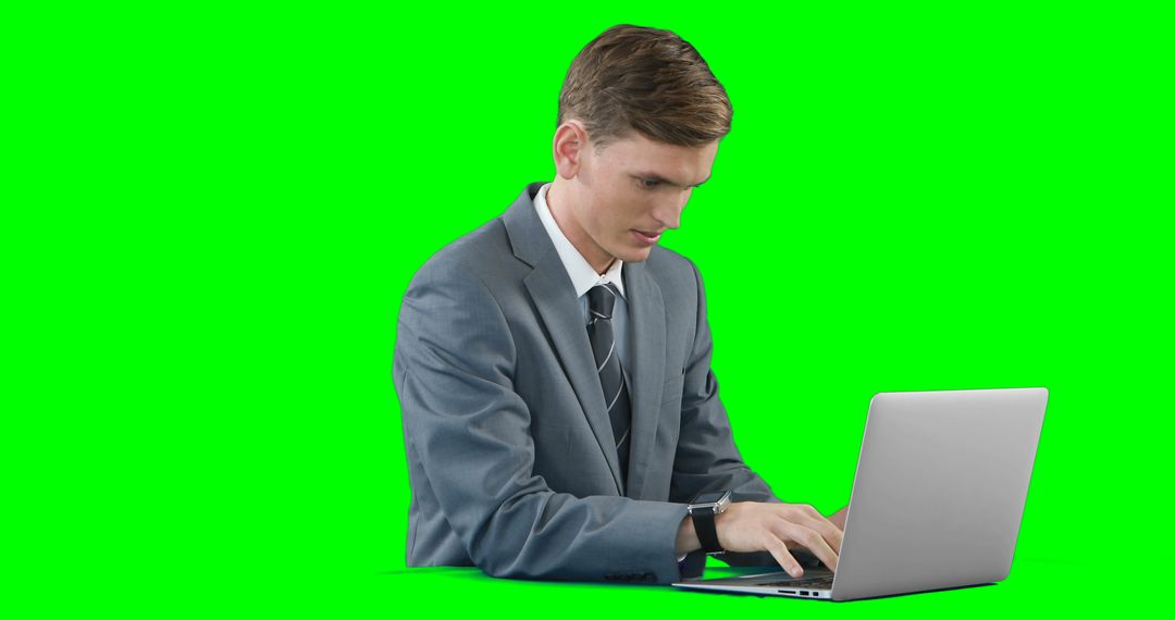 Businessman in Suit Working on Laptop with Green Screen