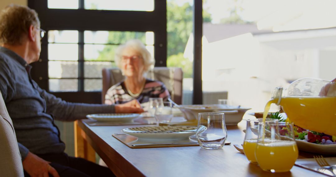 Elderly Couple Having Breakfast at Sunlit Dining Table - Free Images, Stock Photos and Pictures on Pikwizard.com