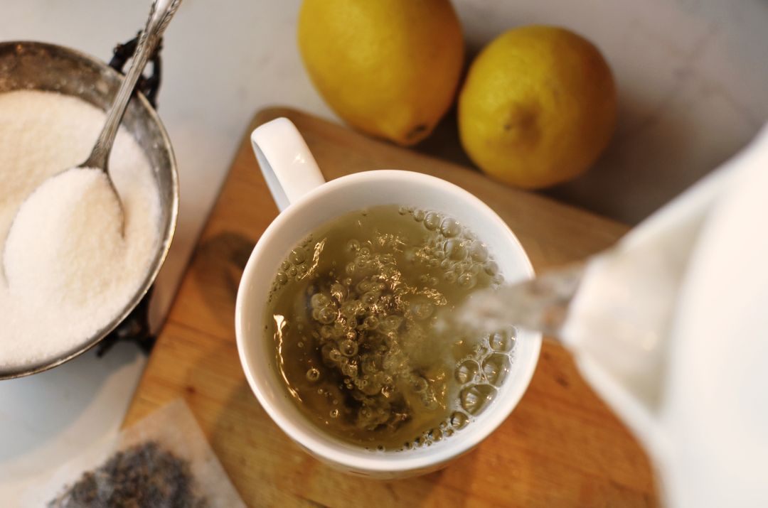 Top View of Herbal Tea Being Poured into Cup with Lemons and Sugar - Free Images, Stock Photos and Pictures on Pikwizard.com