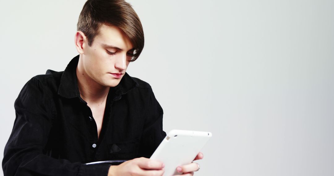 Young Man Using Tablet with Focus and Intensity - Free Images, Stock Photos and Pictures on Pikwizard.com