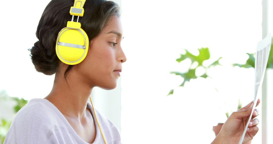 Young Woman Relaxing with Yellow Headphones Near Window