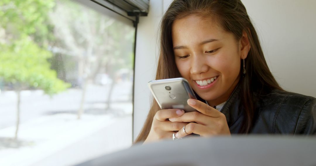 Smiling Young Woman Using Smartphone on Public Transit - Free Images, Stock Photos and Pictures on Pikwizard.com