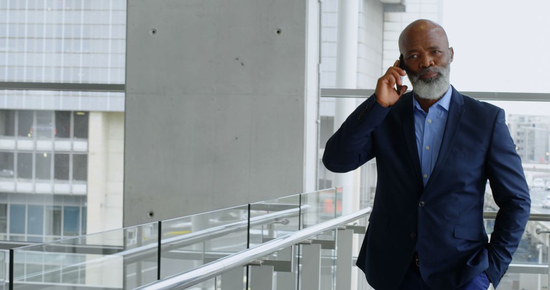 Confident Businessman Having Phone Call in Modern Office Building - Free Images, Stock Photos and Pictures on Pikwizard.com