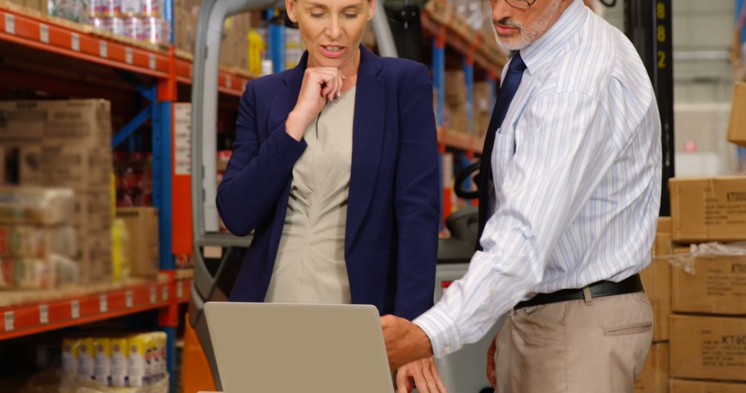 Business Colleagues Analyzing Data on Laptop in Warehouse - Free Images, Stock Photos and Pictures on Pikwizard.com