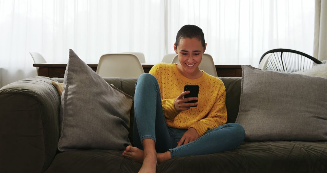 Smiling Woman Relaxed on Sofa Using Smartphone at Home - Free Images, Stock Photos and Pictures on Pikwizard.com