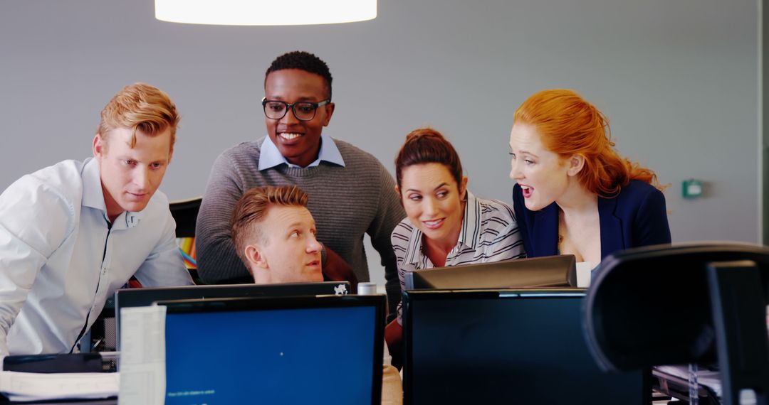 Diverse Business Team Celebrating Success Around Computer in Office