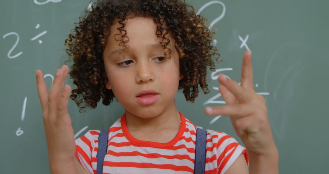 Curly-Haired Boy Counting on Fingers in Classroom