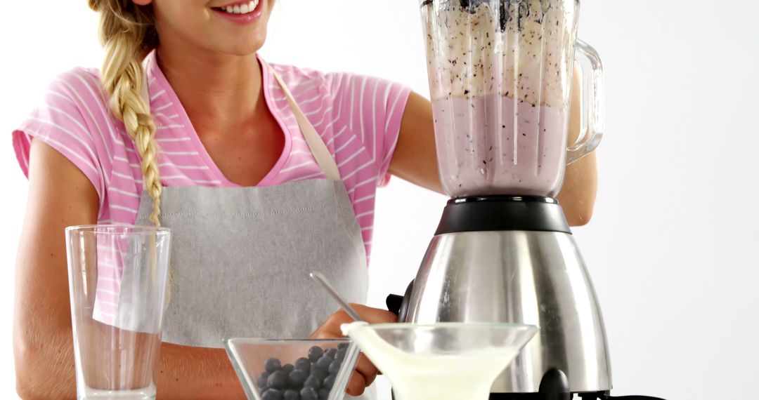 Smiling Woman Making Fresh Smoothie in Modern Kitchen - Free Images, Stock Photos and Pictures on Pikwizard.com