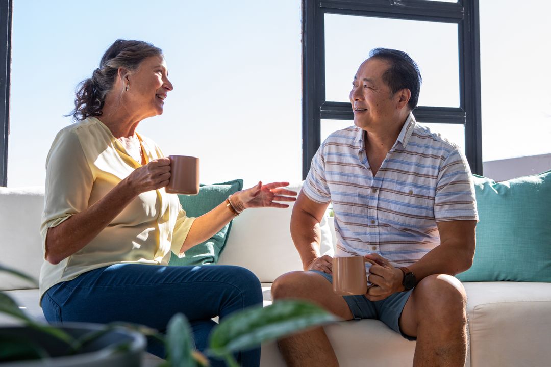 Senior Couple Enjoying Coffee While Engaging in Conversation at Home