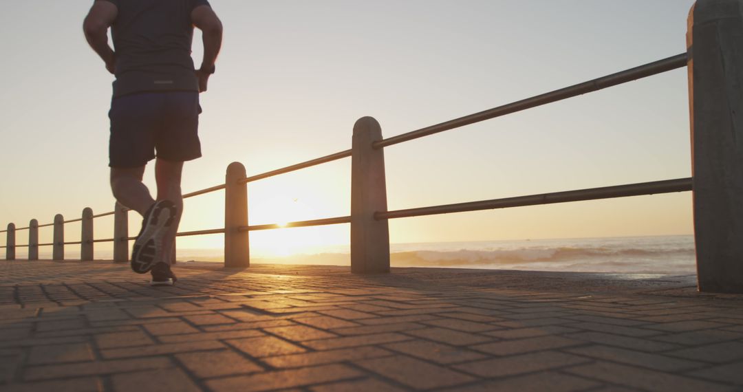 Person Jogging Along Seafront Promenade at Sunrise - Free Images, Stock Photos and Pictures on Pikwizard.com