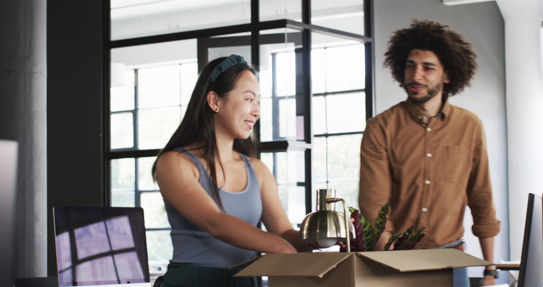 Diverse Colleagues Unpacking Office Items with Smiles