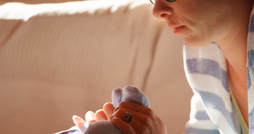 Mother Tenderly Holding Newborn's Hand in Warm Light - Free Images, Stock Photos and Pictures on Pikwizard.com