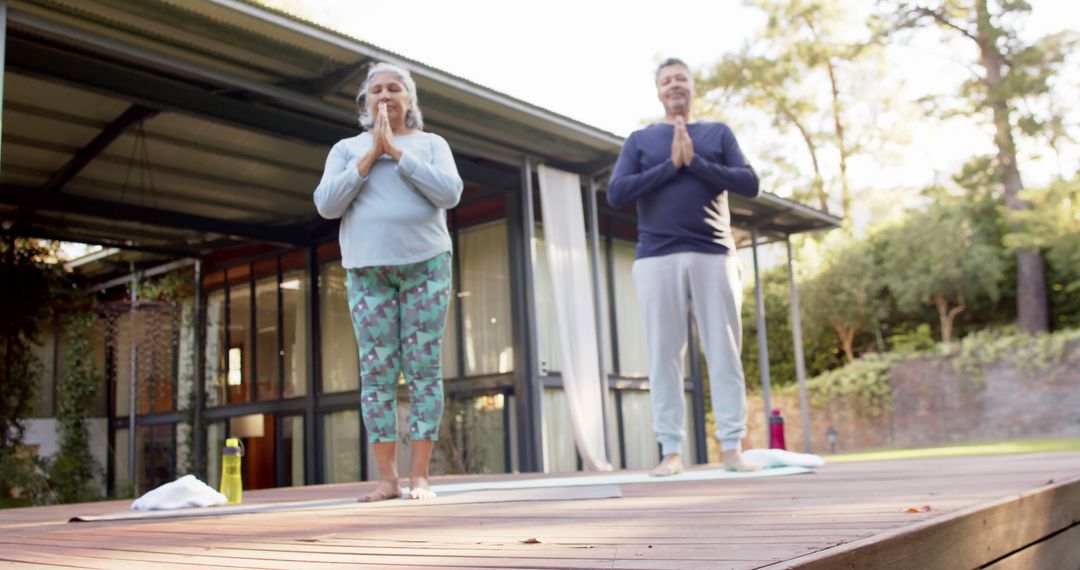 Seniors Practicing Morning Yoga Outdoors on Serene Wooden Deck - Free Images, Stock Photos and Pictures on Pikwizard.com